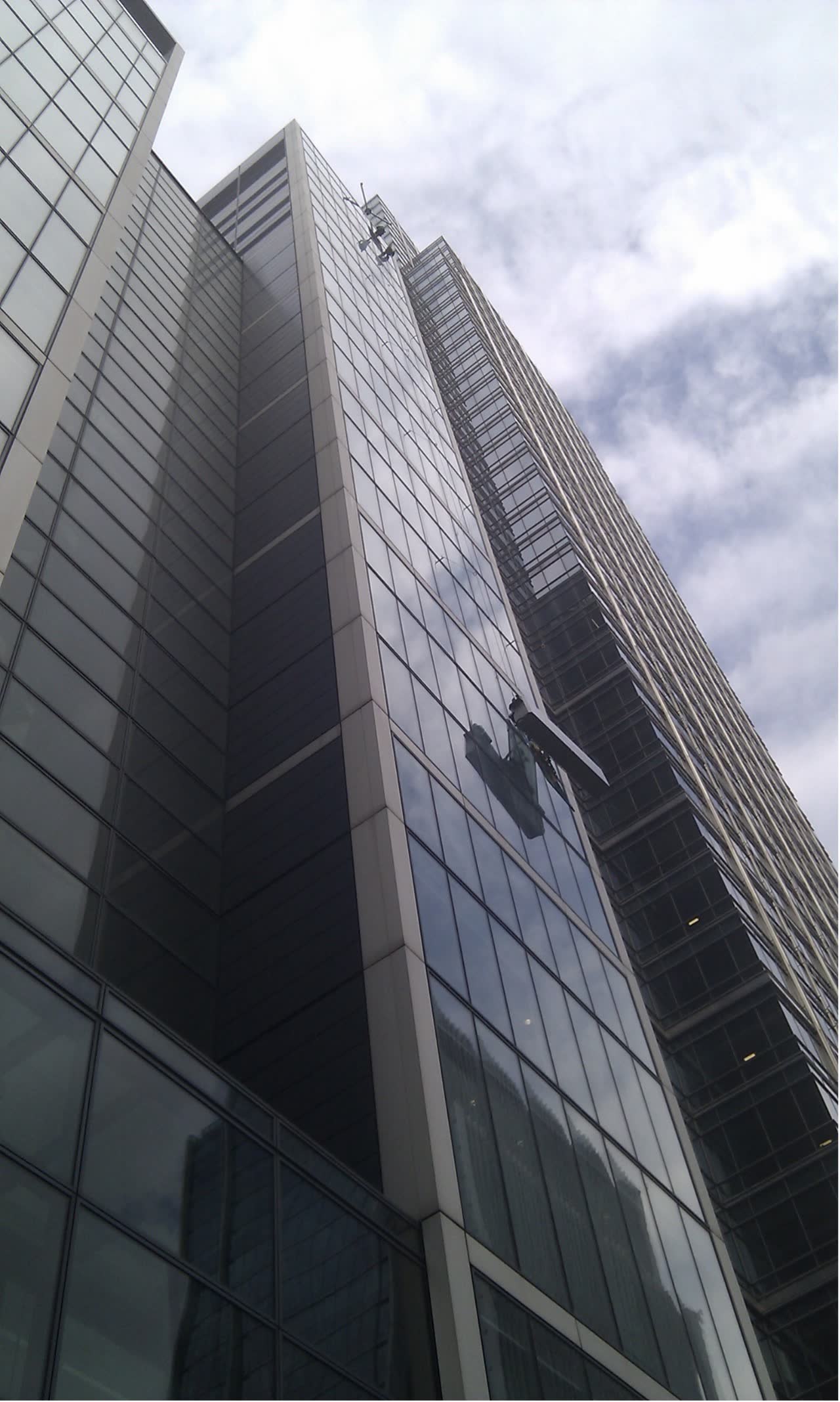 Rope access technician working on high-rise curtain wall glazing in Nottingham city centre