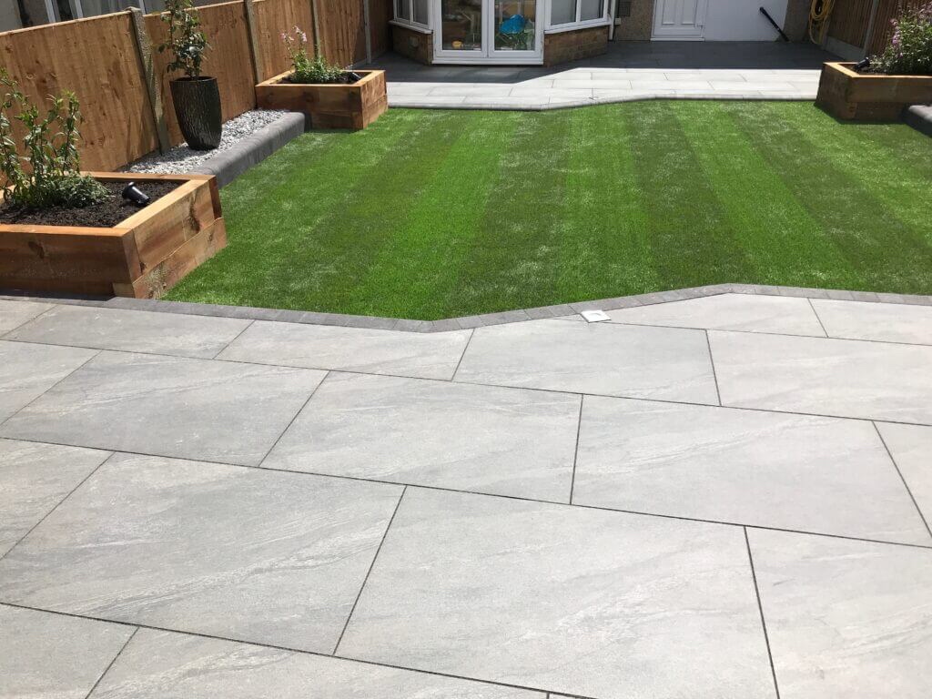 Artificial lawn with raised timber planters and patio surround