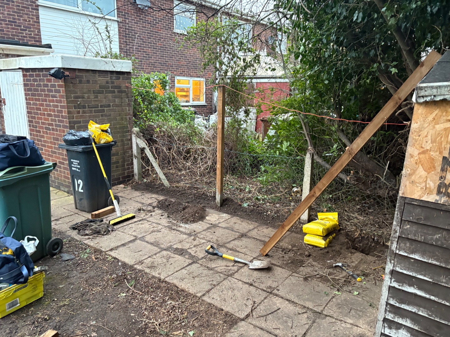 Work in progress — first new posts set in concrete, vegetation cleared