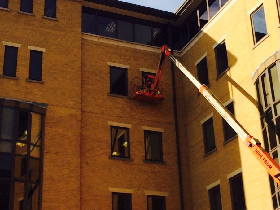 Cherry picker access being used to replace commercial windows on an office building